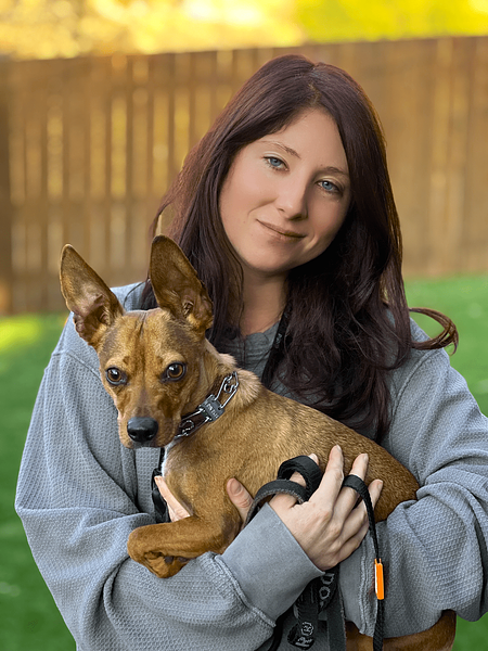 Emily holding a small dog she trained at Hasley Canyon Ranch K9 Training in Castaic, CA