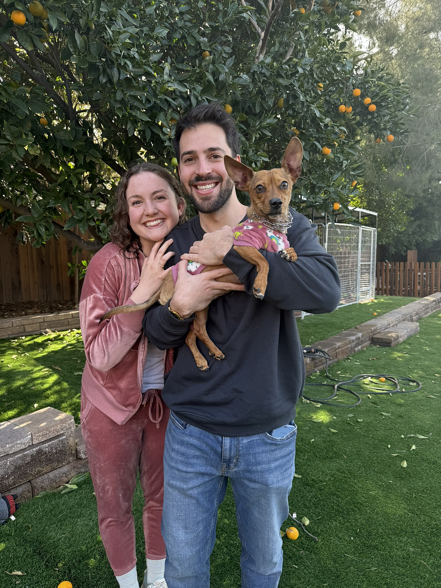A couple holding their small rescue dog after training with Hasley Canyon Ranch K9 Training in Castaic, CA